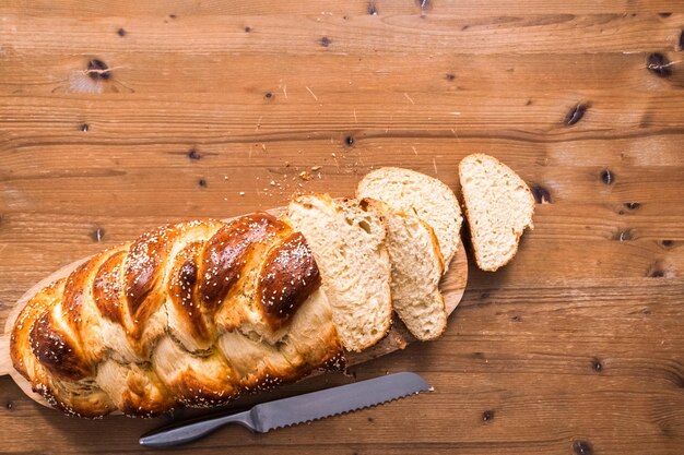 Flach liegen. Geschnittenes frisches Challah-Brot auf dem Holztisch.