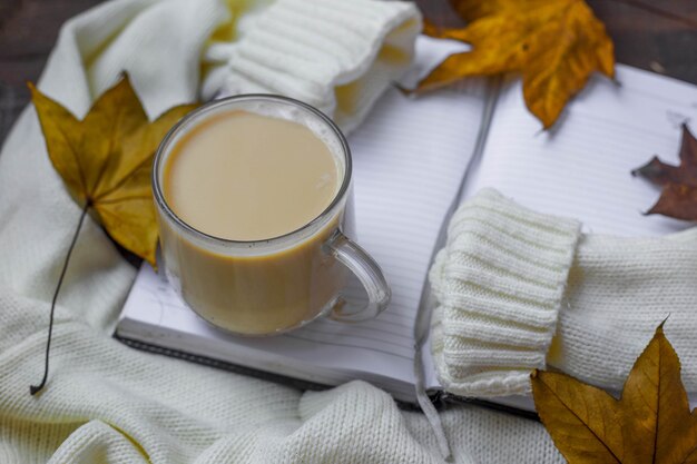 Flach liegen mit Herbstlaub, warmem Pullover und Tasse Kaffee.