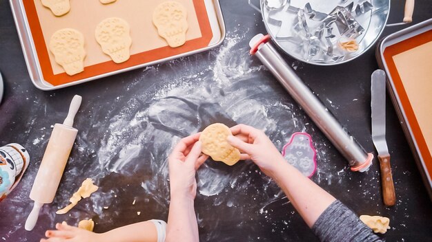 Flach liegen. Mutter und Tochter backen Zuckerschädelkekse für den Feiertag Dia de los Muertos.