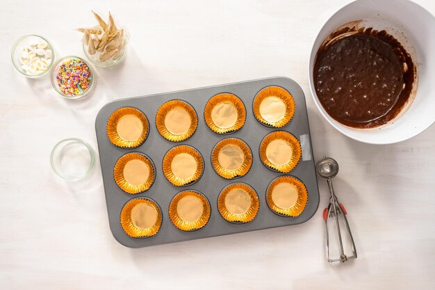 Flach liegen. Schokoladen-Cupcakes in Cupcake-Pfanne backen.