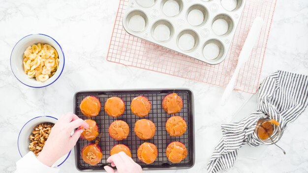 Flach liegen. Schritt für Schritt. Bananenbrot-Muffins mit hausgemachtem Karamell, Bananenchips und Walnüssen garnieren.