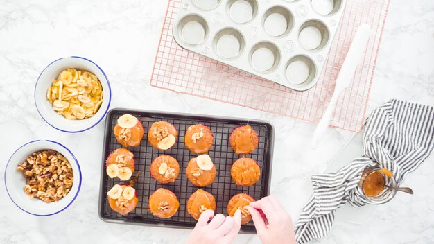 Flach liegen. Schritt für Schritt. Bananenbrot-Muffins mit hausgemachtem Karamell, Bananenchips und Walnüssen garnieren.