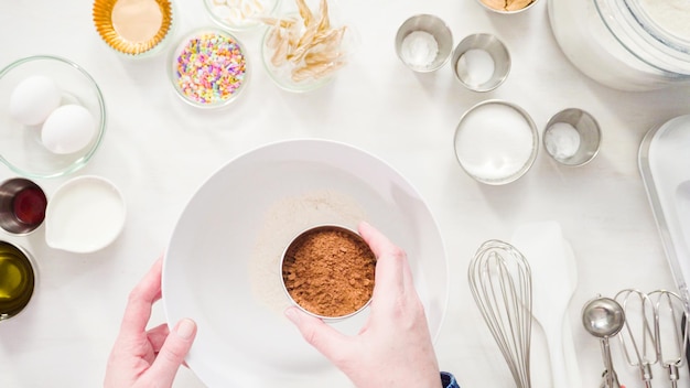 Flach liegen. Schritt für Schritt. Mischen Sie die Zutaten in einer weißen Rührschüssel, um Einhorn-Schokoladen-Cupcakes mit Buttercreme-Zuckerguss zuzubereiten.