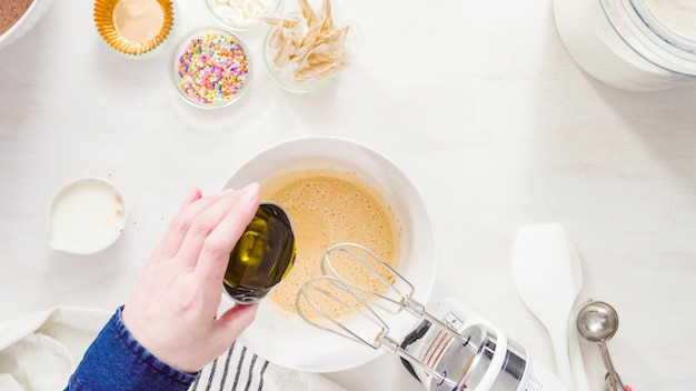 Flach liegen. Schritt für Schritt. Mischen Sie die Zutaten in einer weißen Rührschüssel, um Einhorn-Schokoladen-Cupcakes mit Buttercreme-Zuckerguss zuzubereiten.