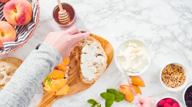 Flach liegen. Schritt für Schritt. Ricotta-Toasts mit Bio-Pfirsichen und Beeren zubereiten.