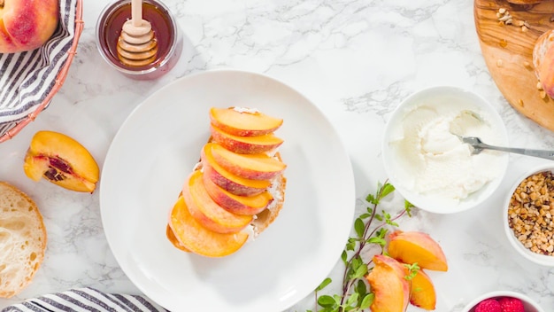 Flach liegen. Schritt für Schritt. Ricotta-Toasts mit Bio-Pfirsichen und Beeren zubereiten.