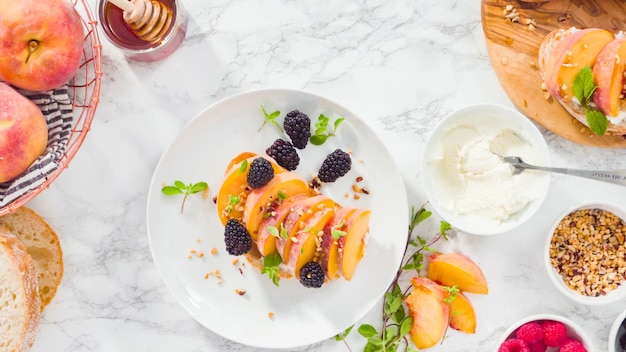 Flach liegen. Schritt für Schritt. Ricotta-Toasts mit Bio-Pfirsichen und Beeren zubereiten.