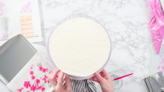 Flach liegen. Schritt für Schritt. Runde Funfetti-Torte mit rosa und weißen Fondant-Schneeflocken dekorieren.