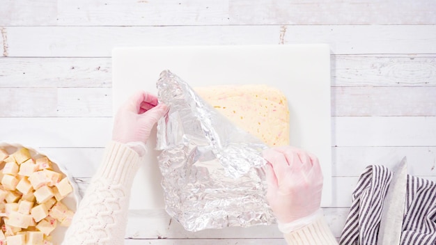 Flach liegen. Schritt für Schritt. Schneiden von hausgemachtem Candy Cane Fudge auf einem weißen Schneidebrett.