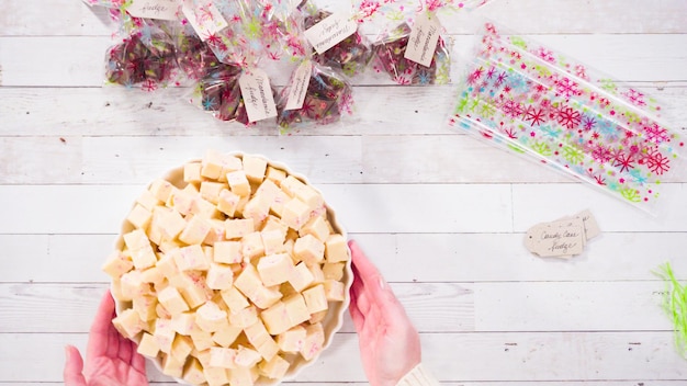 Flach liegen. Schritt für Schritt. Verpacken Sie hausgemachten Zuckerstangen-Fudge in kleine Geschenktüten.