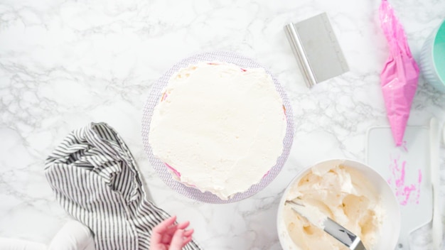 Flach liegen. Schritt für Schritt. Zuckerguss runder Funfetti-Kuchen mit weißem italienischem Buttercreme-Zuckerguss.