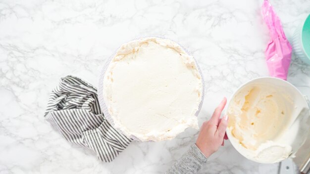 Flach liegen. Schritt für Schritt. Zuckerguss runder Funfetti-Kuchen mit weißem italienischem Buttercreme-Zuckerguss.