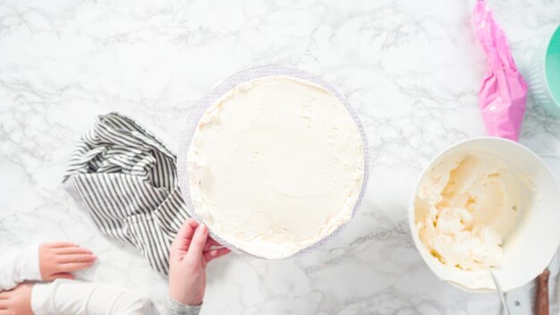 Flach liegen. Schritt für Schritt. Zuckerguss runder Funfetti-Kuchen mit weißem italienischem Buttercreme-Zuckerguss.