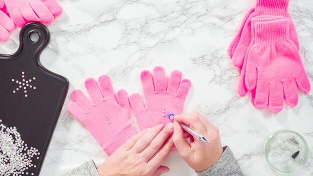 Flach liegen. Strassrosa Kinderhandschuhe mit Schneeflockenformen.