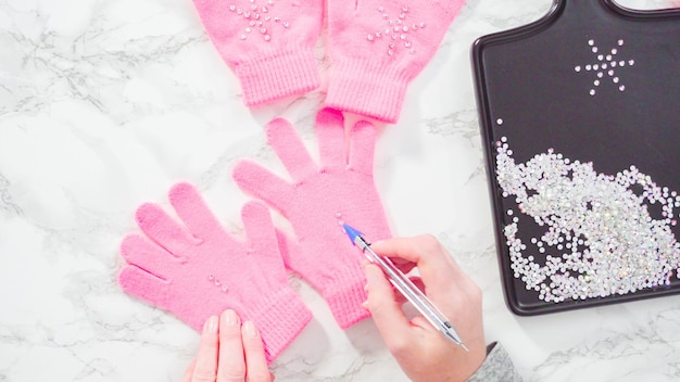 Flach liegen. Strassrosa Kinderhandschuhe mit Schneeflockenformen.