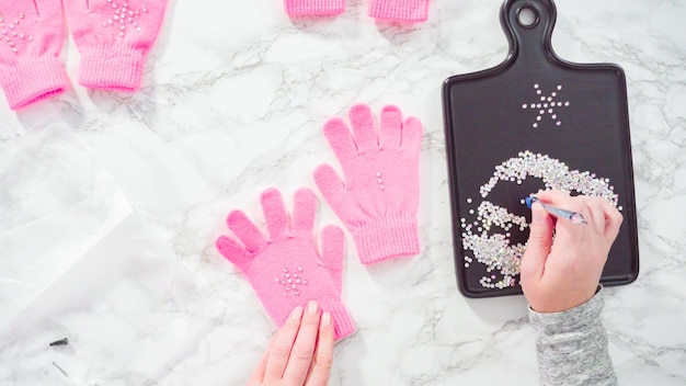 Flach liegen. Strassrosa Kinderhandschuhe mit Schneeflockenformen.