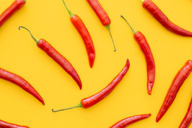 Flach liegend getrocknete rote Chilischoten Muster auf gelbem Hintergrund Draufsicht flach liegend