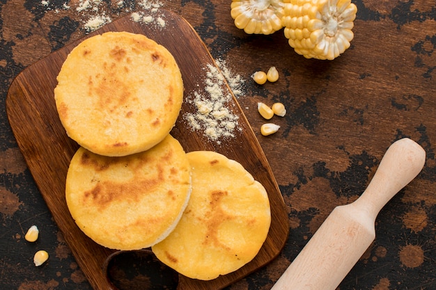 Flach liegende Arepas auf Holzbrett