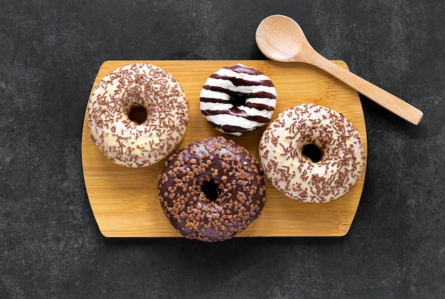 Flache Donuts auf Schneidebrett mit Holzlöffel