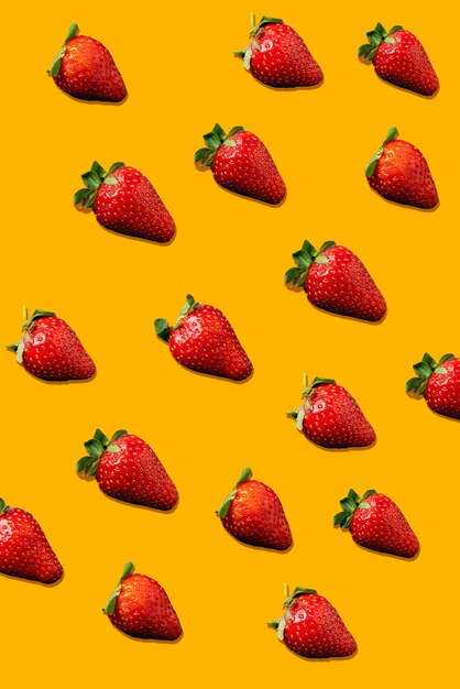 Flache Erdbeeren. Verschiedene reife Erdbeeren isoliert auf orangefarbenem Hintergrund