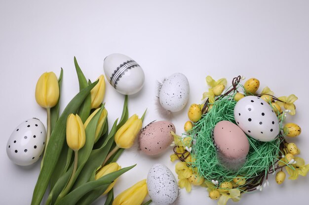 Flache Komposition mit schönen Blumen und Eiern auf weißem Hintergrund Osterfeier