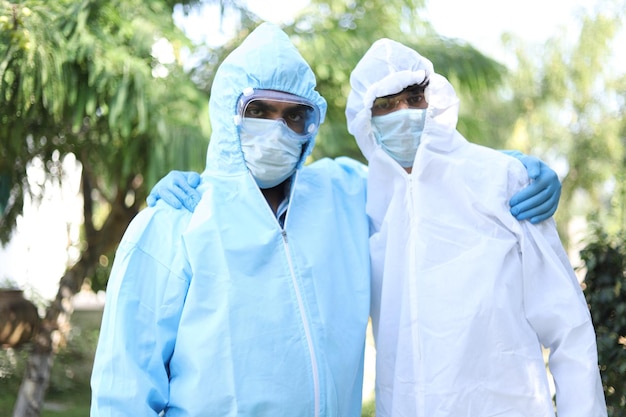 Flache Konzentration von Mitarbeitern des Gesundheitswesens in Schutzanzügen, die sich inmitten der COVID-19-Pandemie gegenseitig unterstützen