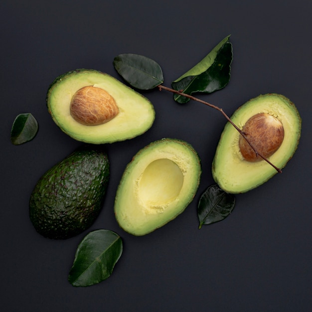 Flache Lage der Avocado mit Grube und Blättern