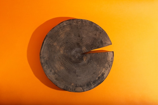 Flache Lage mit leerer Vitrine aus Holzkreispodium auf orangefarbenem Hintergrund
