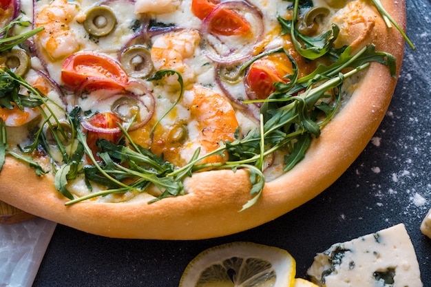 Flache Lage mit traditioneller italienischer Pizza mit Garnelen, Mozzarella und Rucola