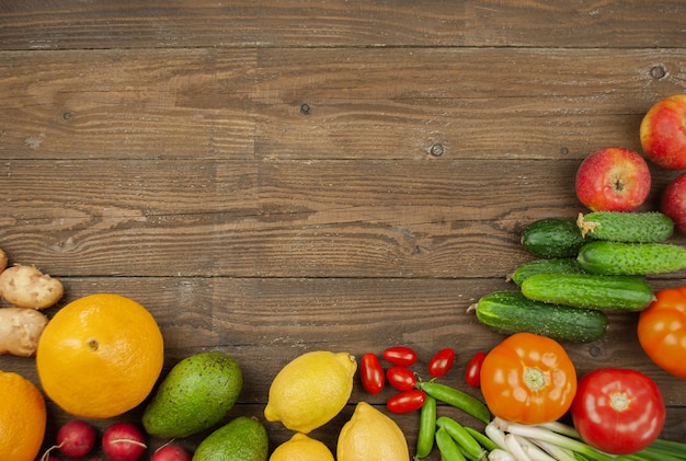 Flache Lage von Obst, Gemüse und Kräutern der Saison. Sommer-Food-Konzept. Gesundes Leben und Vegetarier, Veganer, Diät, saubere Lebensmittelzutaten. Platz für Text. Essen auf dunklem Holzhintergrund.