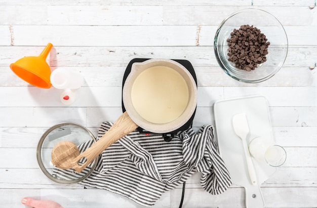 Flache Lage Zubereitung von hausgemachter Schokoladenganache für Schokoladen-Himbeer-Cupcakes