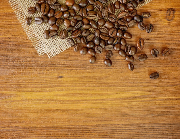 Flache Lagebohnen Kaffeebohnen auf hölzernem Hintergrund mit Kopienraum