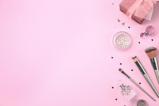 Flache Lay-Komposition mit Kosmetik und stilvollen Accessoires auf rosa Hintergrund Platz für Text