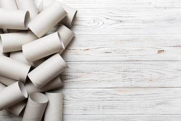 Flache Lay-Komposition mit leeren Toilettenpapierrollen und Platz für Text auf farbigem Hintergrund Recycelbare Papierröhre mit Metallstecker aus Kraftpapier oder Pappe