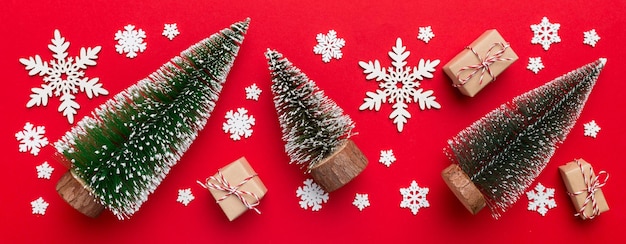 Flache Lay-Komposition mit Weihnachtsbäumen auf farbigem Hintergrund Draufsicht mit Kopierraum