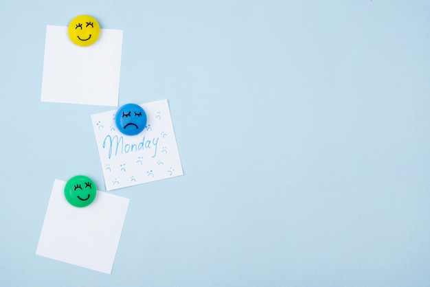 Foto flache schicht von haftnotizen mit traurigem gesicht für blaue montag- und smileygesichter