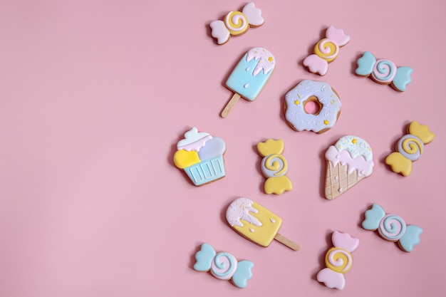 Flache Zusammensetzung mit hell glasierten Lebkuchenplätzchen auf rosa Hintergrundkopierraum.