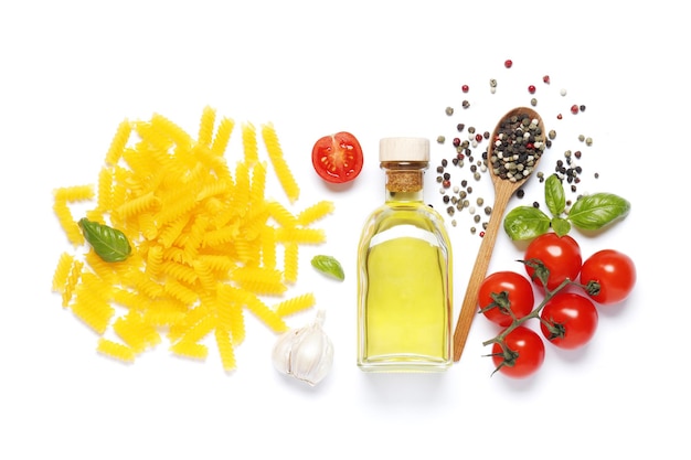 Flache Zusammensetzung von Maisnudeln, Kirschtomaten, Gewürzen, Basilikum, Olivenöl, Knoblauch einzeln auf weißem Hintergrund.