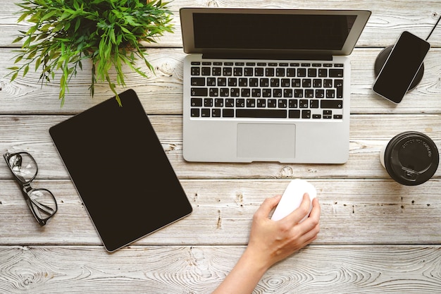 Flacher Lageschreibtisch Arbeitsplatz mit der weiblichen Hand, Draufsicht des Laptops