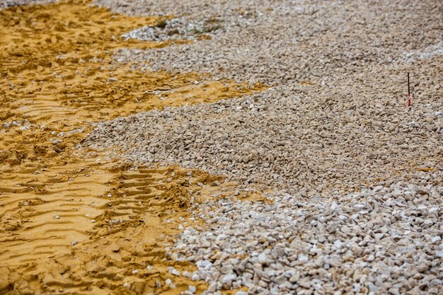 Flacher Sand- und Kiesbereich auf der Baustelle im Vollbildhintergrund