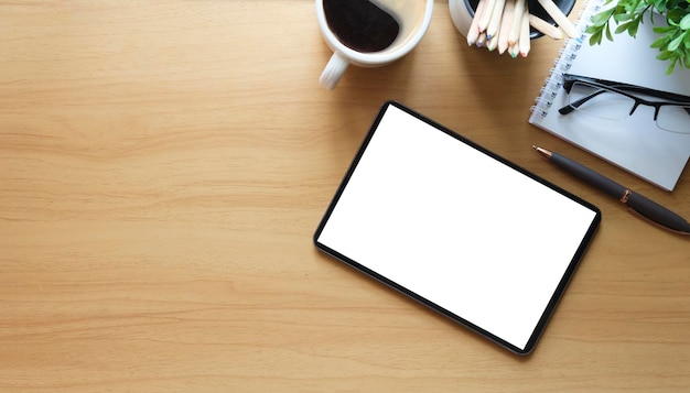 Flaches digitales Lat-Tablet mit leerem Kaffeetassen-Briefpapier und Zimmerpflanze auf Holztisch