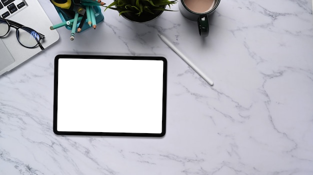 Flaches Foto des Arbeitsplatzes mit digitalem Tablet, Laptop und Kaffeetasse auf Marmorbeschaffenheitshintergrund.