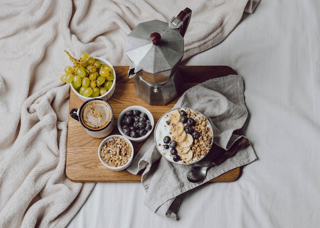 Flaches Frühstück im Bett mit Müsli und Kaffee