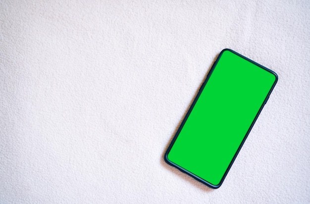 Flaches Lay-Foto des Smartphone-Greenscreen-Chroma-Key-Telefonbildschirms in vertikaler Position
