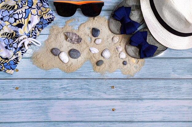 Flaches Lay-Sommer-Hintergrund-Strandzubehör auf einem blauen Holztisch für Reisekopierraum