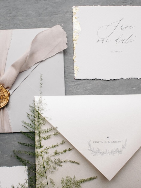 Flachlag von minimalistischen Hochzeits-Einladung Details Briefe Pflanze