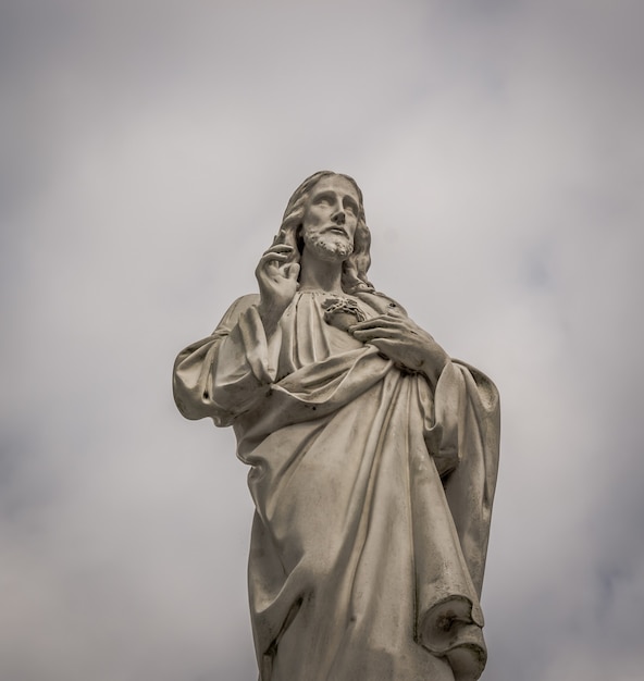 Flachwinkelaufnahme der Jesus-Statue mit erhobenen Fingern an einem bewölkten Tag