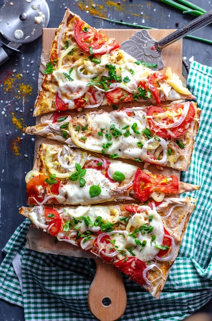 Fladenbrot gesunde Pizzastücke mit Huhn, Tomaten, Pfeffer, Mozzarella auf Holz