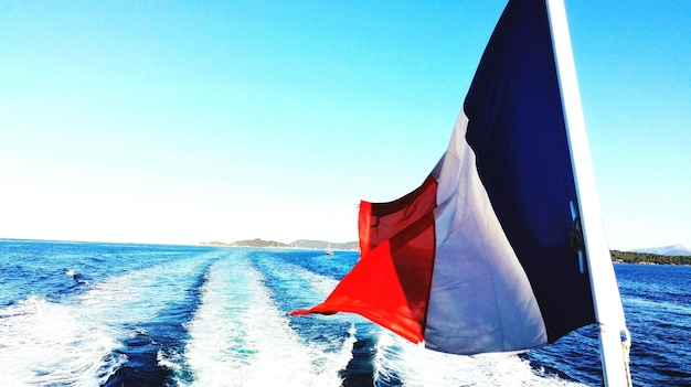 Foto flagge am meer gegen den klaren blauen himmel