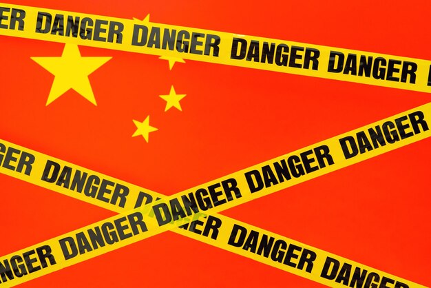 Flagge Chinas mit Gefahrenband im Vordergrund Konzept der Gefahr, in das chinesische Land neue Welle von Covid19 einzudringen